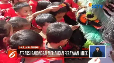 Atraksi barongsai di Solo, Jawa Tengah, pukau ratusan siswa SD yang tengah menyaksikan. Para siswa tersebut pun antusias berebut memasukkan angpau ke dalam mulut barongsai.