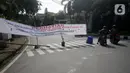 Pengendara sepeda motor melintas dekat spanduk pemberitahuan penutupan jalan di kawasan perumahan Pondok Indah, Jakarta Selatan, Senin (30/2/2020). Perumahan di Pondok Indah menerapkan akses masuk satu pintu untuk mencegah penyebaran virus corona COVID-19. (merdeka.com/Dwi Narwoko)