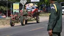 Konflik perbatasan ini berakar pada perselisihan wilayah sepanjang 817 kilometer yang telah berlangsung lebih dari satu abad atau sejak batas wilayah dipetakan oleh Prancis pada tahun 1907. Tampak dalam foto, seorang polisi (kanan) berdiri saat warga dievakuasi menyusul bentrokan di sepanjang perbatasan Kamboja-Thailand di Provinsi Siem Reap pada Selasa 9 Desember 2025. (TANG CHHIN SOTHY/AFP)