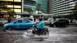 Sejumlah kendaraan melintas menerjang genangan air di kawasan Bunderan HI, Jakarta, Kamis (22/11). Genangan air hujan setinggi 40 cm tersebut disebabkan hujan deras yang melanda Jakarta pada siang hari. (Liputan6.com/Faizal Fanani)