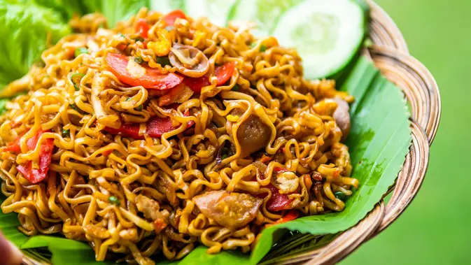 Sepiring mie goreng sosis yang menggugah selera dengan tambahan irisan sosis, sayuran segar, dan taburan daun bawang