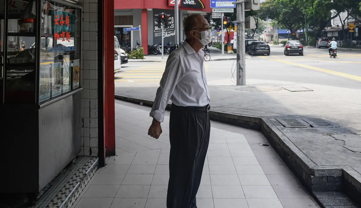 Seorang lelaki tua mengenakan masker saat kabut menyelimuti Kuala Lumpur, Malaysia (10/9/2019). Ratusan sekolah di seluruh Asia Tenggara ditutup karena kabut asap beracun akibat kebakaran hutan. (AFP Photo/Mohd Rasfan)