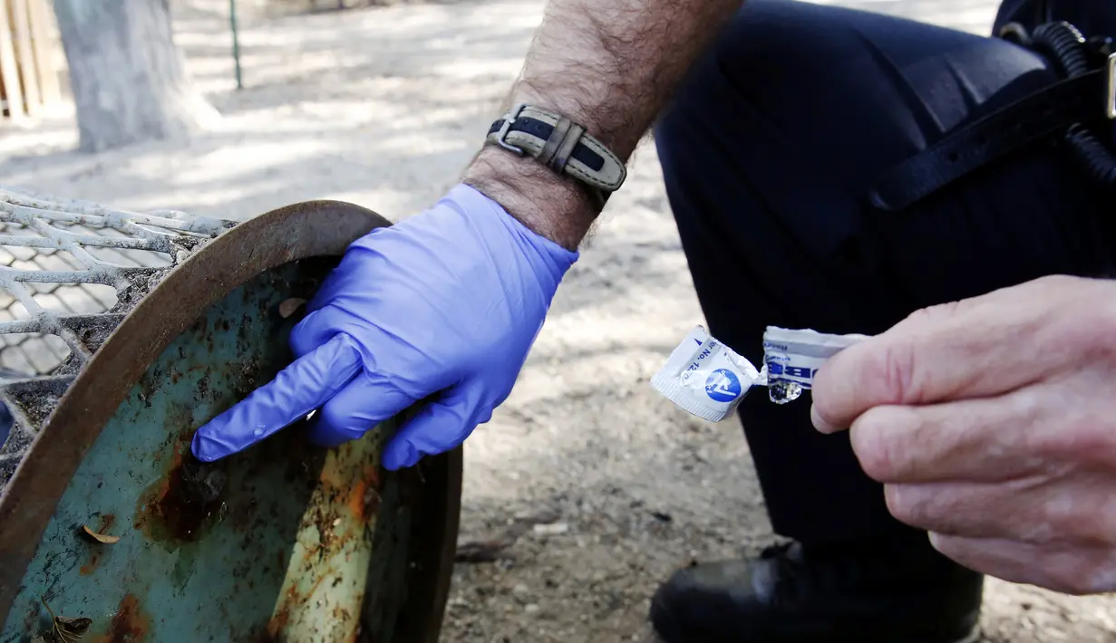 Petugas menambal lubang tong sampah dimana seekor tikus terjebak di Brooklyn, New York, Amerika Serikat, (18/10). Supaya tidak terjadi lagi, petugas menambal lubang yang menjebak tubuh si tikus. (REUTERS/Lucas Jackson)