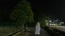 Urabil Alias, 38, mengenakan kostum hantu saat berjalan di daerah perumahan selama aturan pembatasan gerakan atau Movement Control Order di Terengganu, Malaysia, 16 April 2020. Aksi pria itu untuk menakuti warga agar tidak keluar dari rumah selama lockdown akibat virus corona. (Mohd RASFAN/AFP)
