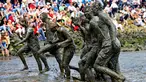 Peserta berjalan meninggalkan lapangan usai bermain bola tangan yang dinamakan "Wattoluempiade" (Olimpiade Lumpur) di Brunsbuettel, Jerman, (30/7). (REUTERS/Fabian Bimmer)