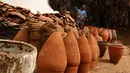 Pekerja menjemur pot tanah liat di sebuah bengkel tembikar di Khartoum, Sudan, Kamis (27/6/2019). Pot tanah liat tersebut nantinya akan dipajang untuk dijual. (AP Photo/Hussein Malla)