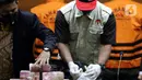 Petugas menunjukkan barang bukti hasil OTT Bupati Langkat, Terbit Rencana Perangin Angin saat rilis penahanan tersangka di Gedung KPK, Jakarta, Kamis (20/1/2022). KPK resmi menahan Bupati Langkat, Terbit Rencana Perangin Angin dan menyita uang sebesar Rp 786 juta. (Liputan6.com/Helmi Fithriansyah)