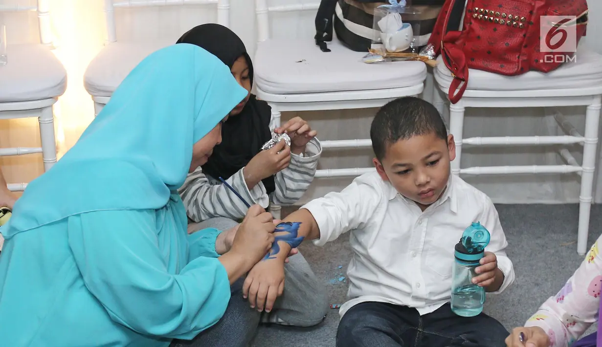 Anak kedua Krisdayanti dengan Raul Lemos, Kellen saat tangannya dilukis di kawasan Tebet, Minggu (27/08). Anak-anak ini asyik bermain saat menghadiri acara potong rambut anak kedua Ayu Dewi. (Liputan6.com/Herman Zakharia)