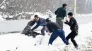 Pemuda Kashmir bermain dengan salju di tepi Danau Dal setelah salju turun di Srinagar, India bagian utara, Sabtu (5/1). Wilayah Kashmir mengalami salju selama beberapa hari yang mengakibatkan terputus jalan raya Jammu-Srinagar. (TAUSEEF MUSTAFA/AFP)