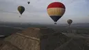 Balon udara yang dipenuhi turis terbang di atas piramida Matahari di situs arkeologi Teotihuacan, tepat di utara Mexico City, Minggu, 24 Desember 2023. (AP Photo/Marco Ugarte)