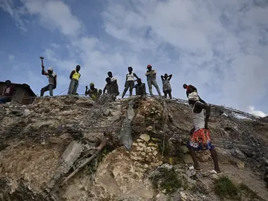 Orang-orang bekerja di antara puing-puing setelah gempa bumi melanda Haiti barat di Jeremie, Haiti pada 6 Juni 2023. (AFP/Richard Pierrin)