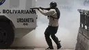 Petugas menembakan peluru karet ke arah anggota oposisi saat bentrokan di Caracas, Venezuela, (4/4). Para demonstran berusaha untuk menemani anggota parlemen oposisi dalam sesi wacana penghapusan Mahkamah Agung. (AP Photo / Ariana Cubillos)