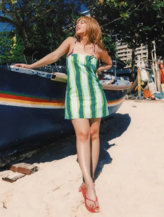 Vanesha  pun tampil dengan mini dress hijau, dipadukan sandal jepit warna merahnya. Credit: Havaianas