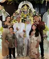 Sementara itu, Ashanty mengenakan dress panjang coklat keemasan lengan panjang hitam brokat. Anang mengenakan batik yang serasi dengan Arsya. Arsy tampil cantik dengan dress panjang motif bunga 3D. [@ashanty_ash]