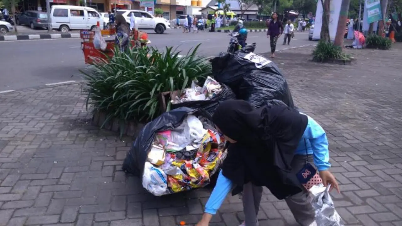 Siswa memunguti sampah usai Istigasah Kubro di GOR Sidoarjo