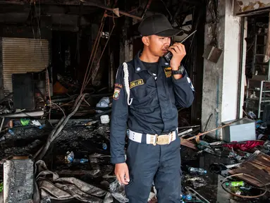 Seorang satpam mengecek keadaan kios usai terbakar di Pasar Senen, Jakarta, Jumat (20/1). Badan Penanggulangan Bencana Daerah DKI Jakarta menyatakan jumlah kios Pasar Senen sebanyak 1.691 kios. (Liputan6.com/Gempur M Surya)