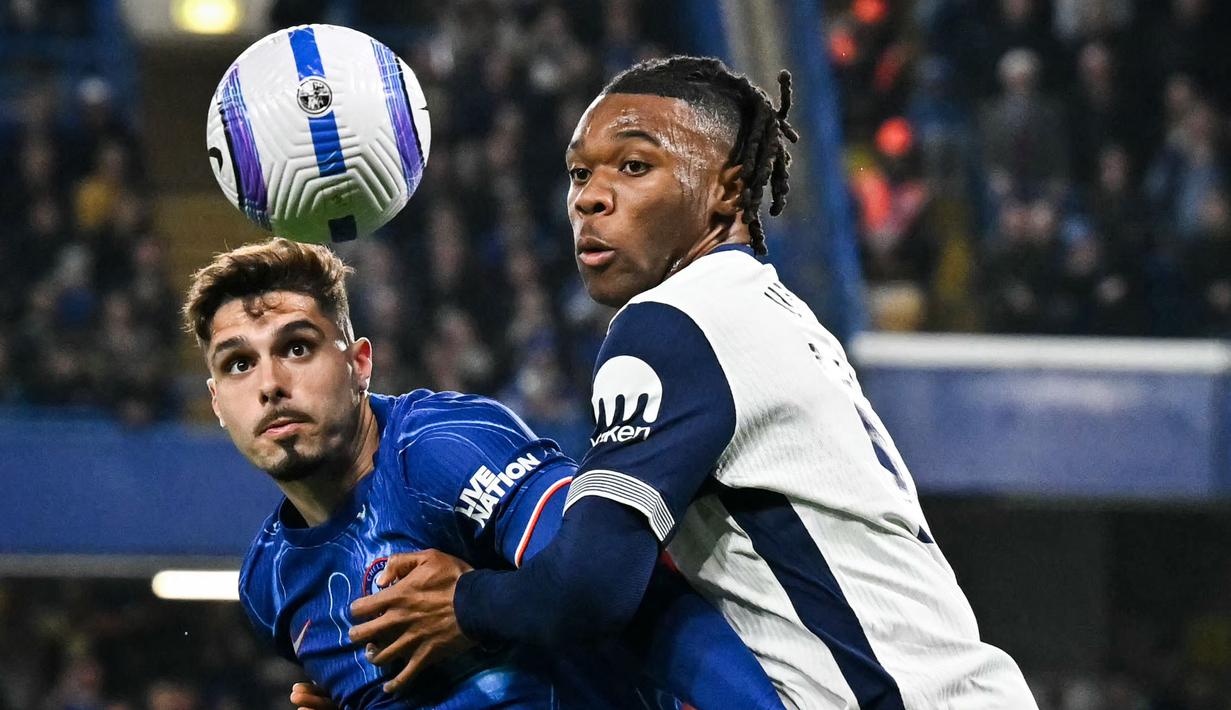 Pemain Chelsea, Pedro Neto (kiri) berebut bola dengan pemain Tottenham Hotspur, Destiny Udogie dalam laga lanjutan Liga Inggris 2024/2025 yang berlangsung di Stamford Bridge, London, Kamis (03/04/2025) waktu setempat. (AFP/Glyn Kirk)
