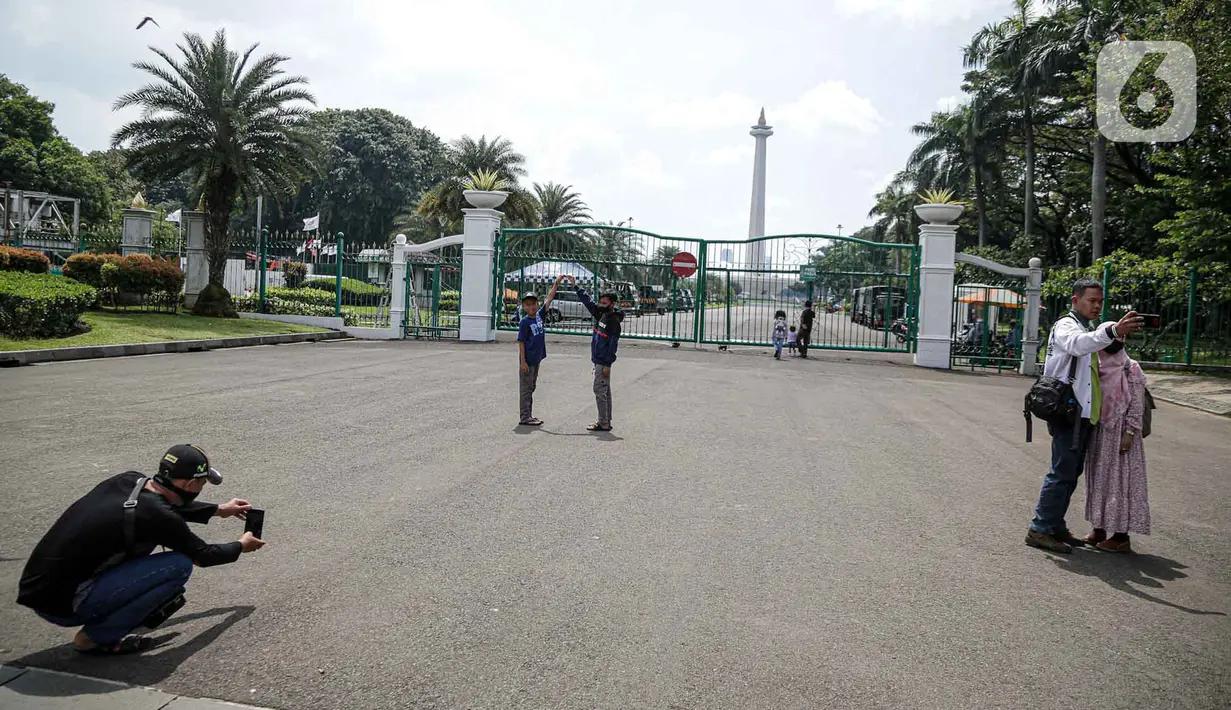 <p>Warga berfoto di halaman luar Monumen Nasional (Monas) Jakarta, Kamis (5/5/2022). Meski kawasan Monas masih ditutup sejak awal pandemi COVID-19 pada Maret 2020 lalu namun tidak menyurutkan minat warga untuk bisa berwisata yaitu dengan memanfaatkan kawasan luar monumen tersebut. (Liputan6.com/Faizal Fanani)</p>