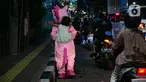 Warkuatno (41) bersama anak sulungnya, Bunga (9) berjalan kaki di pinggir Jalan Raya Fatmawati, Cilandak, Jakarta, Rabu (6/1/2021). Warkuatno harus memutar otak demi bisa bertahan hidup usai kehilangan pekerjaannya. (Liputan6.com/Faizal Fanani)