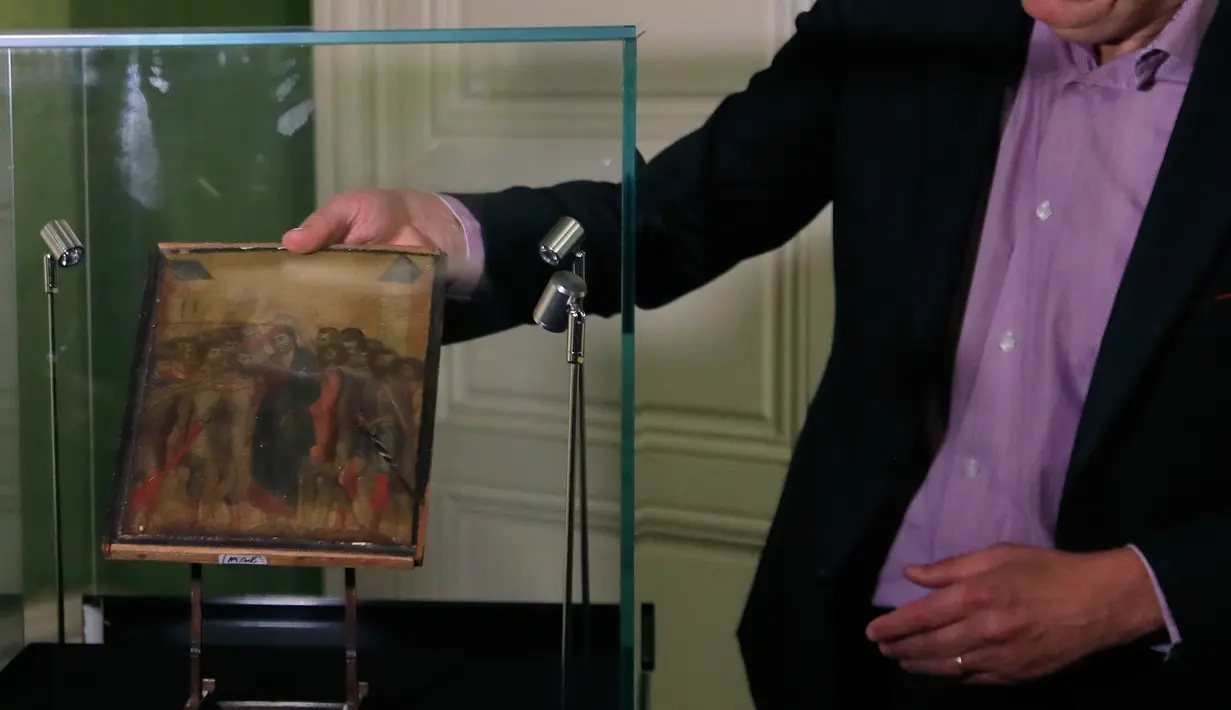 Pakar seni Stephane Pinta memperlihatkan lukisan “Christ Mocked” karya seniman Cimabue dari abad ke-13 di Paris, 24 September 2019. Lukisan yang akan dijual lewat lelang pada 27 Oktober 2019 itu diperkirakan bernilai antara 4 hingga 6 juta euro  (Rp61,3 miliar-Rp92 miliar). (AP/Michel Euler)