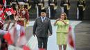 Presiden Republik Indonesia Prabowo Subianto (kiri) bersam Presiden Peru Dina Boluarte menyaksikan anak-anak mengibarkan bendera kedua negara sebelum pertemuan mereka di Istana Merdeka, Jakarta, pada 11 Agustus 2025. (Bay ISMOYO/AFP)