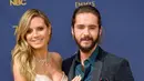 Model senior Heidi Klum dan pacarnya, Tom Kaulitz saat menghadiri Emmy Awards 2018 di Los Angeles, AS, Senin (17/9). Romansa keduanya mulai terkuak ketika mereka kedapatan berciuman di lokasi syuting 'America's Got Talent' Maret lalu. (VALERIE MACON/AFP)