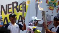 Gubernur Jateng, Ganjar Pranowo saat memegang Obor Asian Games 2018 di Solo, Kamis (19/7/2018). (Bola.com/Ronald Seger)