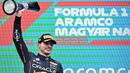 Pebalap Oracle Red Bull Racing, Max Verstappen mengangkat trofi usai memenangkan balapan Formula 1 GP Hungaria yang berlangsung di Sirkuit Hongaronging, Budapest, pada Minggu (31/7/2022). (AFP/Attila Kisbenedek)