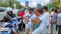 Suasana relawan Gajah Gibran membagikan susu, poster hingga kaos kepada pengendara di Cirebon. (Ist)
