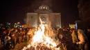 Sejumlah orang menghadiri upacara pembakaran cabang pohon oak kering  atau Yule log selama perayaan Hari Natal Ortodoks di Belgrade, Serbia (6/1). (AFP/Oliver Bunic)
