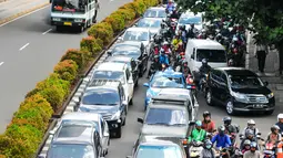 Sejumlah kendaraan terjebak di jalur lambat Jl HR Rasuna Said, Kuningan,  Jakarta Selatan, Rabu (4/5). Ribuan bidan desa menggelar aksi demo dan menutup akses jalur lambat di depan kantor Kemenkes. (Liputan6.com/Yoppy Renato)