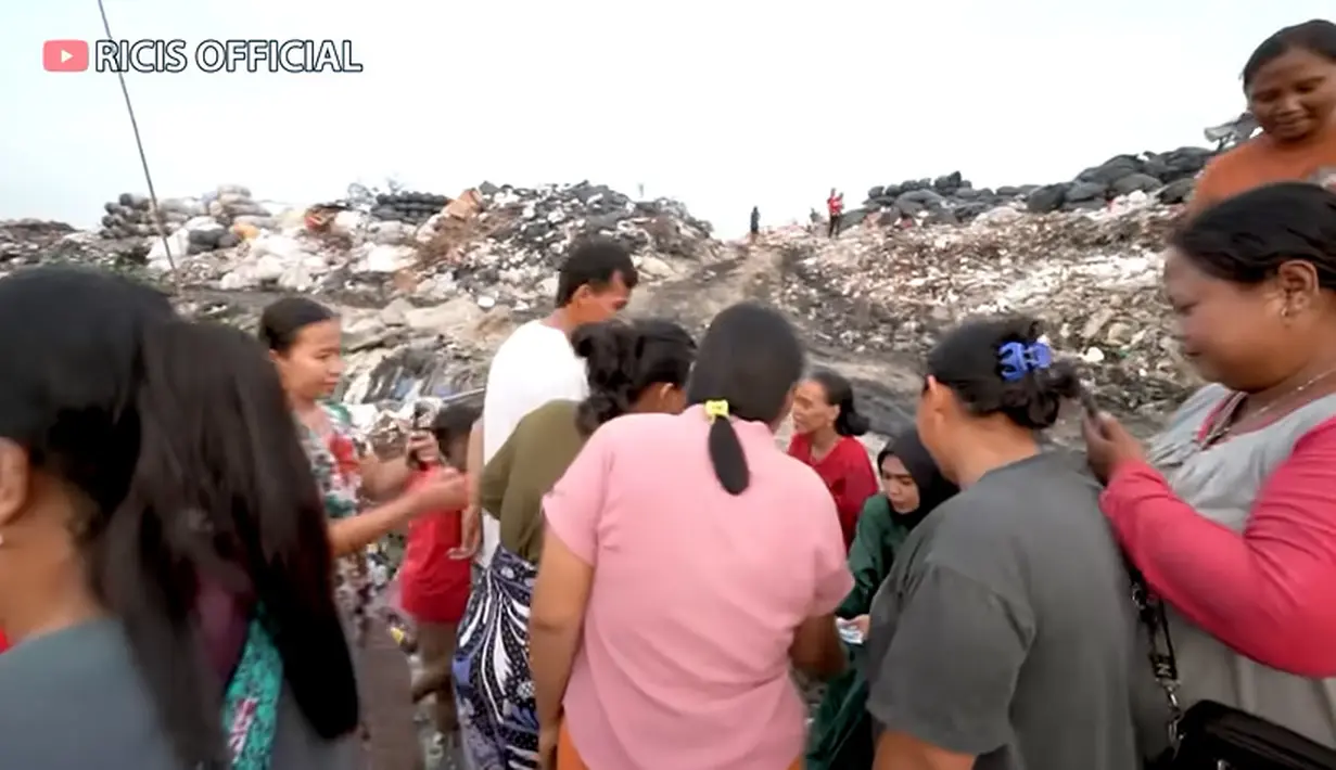 Selesai makan, dan mengajak nyanyi anak-anak, Ria Ricis juga bagi-bagi uang buat anak-anak hingga orang tua. Potret Ricis bagi-bagi uang kepada orang-orang yang ada di tempat pembuangan sampah. [Youtube/Ricis Official]
