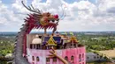 Pemandangan udara pada 11 September 2020 menunjukkan kuil Budha Wat Samphran (Kuil Naga) di Nakhon Pathom, sekitar 40 km sebelah barat Bangkok. Kuil dengan 17 lantai itu berwujud sebuah menara berwarna merah muda yang dililit oleh naga hijau bersisik. (Photo by Mladen ANTONOV / AFP)