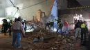 Petugas dibantu sejumlah orang mencari korban yang tertimbun puing sesaat setelah gedung bioskop tua runtuh di Tucuman, Argentina, Rabu (23/5). Sedikitnya satu orang tewas akibat kejadian tersebut. (AFP PHOTO/Walter Monteros)