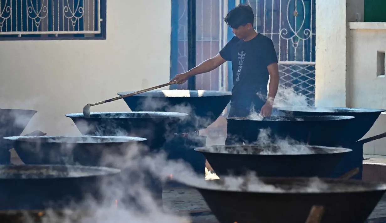 Hidangan ini berupa kari daging (sapi, kambing, atau kerbau) yang dimasak dengan nangka muda serta berbagai rempah pilihan dalam belanga besar. Tampak dalam foto, seorang pria memasak hidangan kari tradisional yang disebut 'kuah beulangong' untuk dibagikan saat berbuka puasa, sekaligus memperingati turunnya Al-Quran selama bulan suci Ramadan, di Banda Aceh pada Sabtu 7 Maret 2026. (CHAIDEER MAHYUDDIN/AFP)