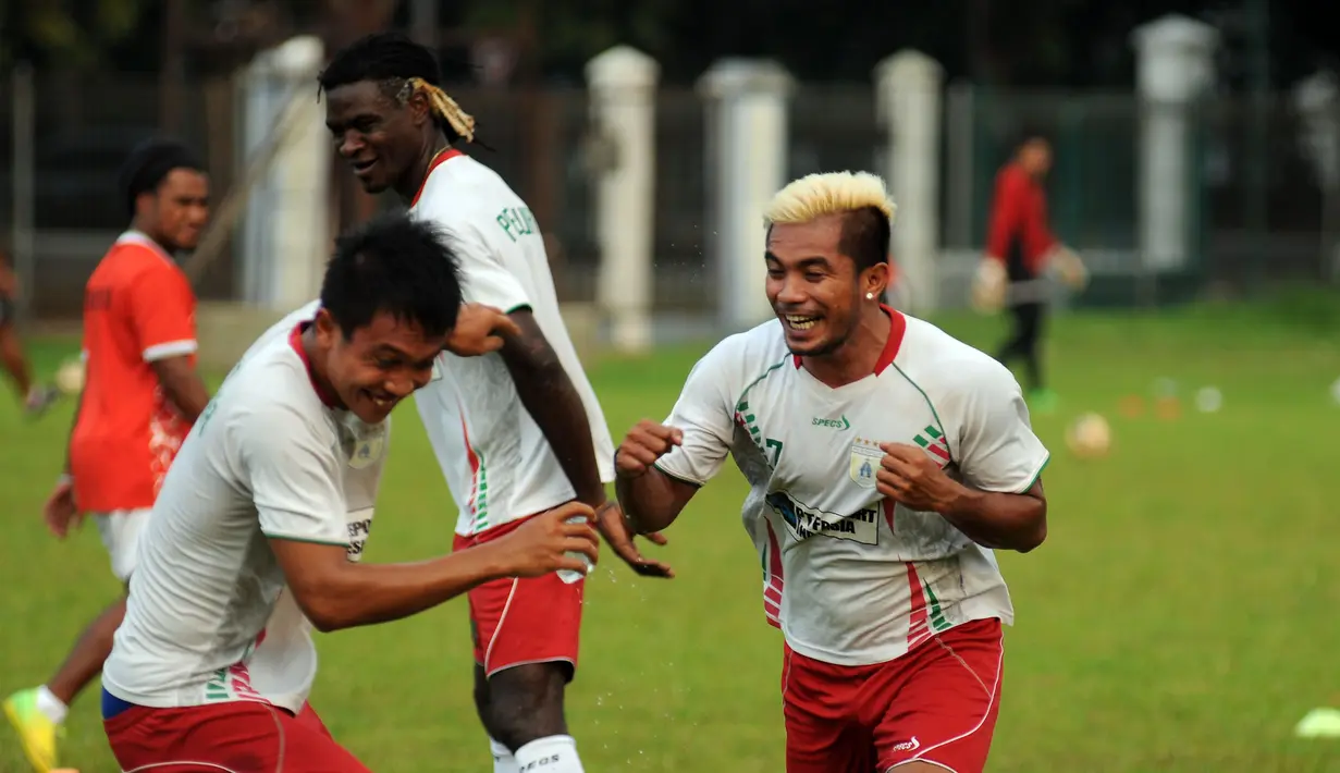 Gelandang Persipura, Zulham Malik Zamrun bercanda dengan rekannya di sela-sela latihan di Lapangan C Senayan, Jakarta, Kamis (7/5/2015). Latihan tersebut merupakan persiapan jelang AFC 2015. (Liputan6.com/Helmi Fithriansyah)