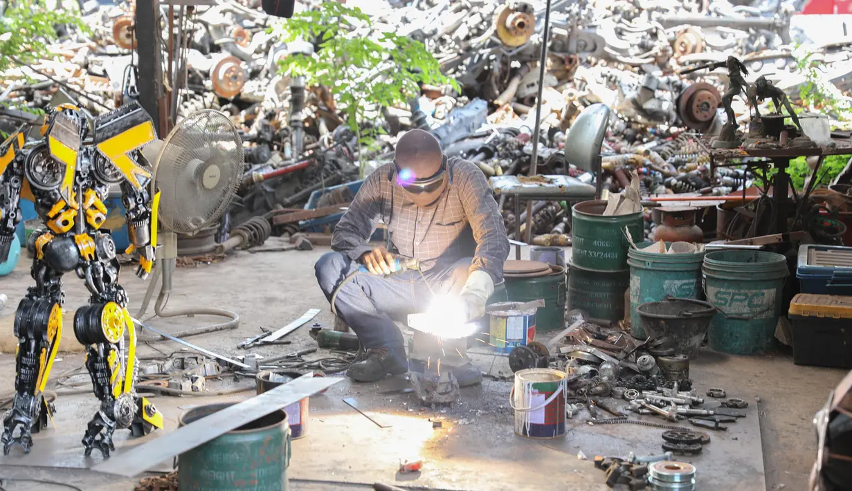 Seorang seniman mengelas bagian-bagian robot di "Ban Hun Lek", atau "Rumah Robot Baja", di Provinsi Ang Thong, Thailand tengah (5/6/2020). Rongsokan mekanik yang tampaknya tidak berharga disulap oleh pengrajin bengkel tersebut menjadi karya seni unik dan eksentrik. (Xinhua/Zhang Keren)