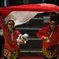 Pasangan pesilat Indonesia peraih medali emas, Ayu Sidan Wilantari dan Ni Made Dwiyanti membentangkan bendera merah putih usai penyerahan medali nomor seni ganda putri di Padepokan Pencak Silat TMII, Jakarta, Rabu (29/8). (Merdeka.com/Imam Buhori)