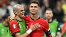 Pemain Portugal, Crsitiano Ronaldo, bersama Pepe tertawa saat timnya berhasil menaklukkan Slovenia pada babak 16 besar Euro 2024 di Frankfurt Arena, Selasa (2/7/2024). Selecao das Quinas menang adu penalti dan lolos ke perempat final. (AFP/Patricia De Melo Moreira)