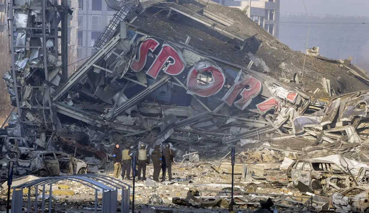 Orang-orang memeriksa kerusakan setelah serangan sebuah pusat perbelanjaan di Kiev, Ukraina, Senin (21/3/2022). Delapan orang tewas dalam serangan tersebut. (AP Photo/Efrem Lukatsky)