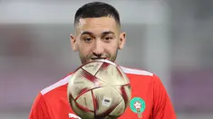 Gelandang Maroko, Hakim Ziyech menatap bola saat ia mengambil bagian dalam sesi latihan di Stadion Al Duhail SC di Doha pada 13 Desember 2022. Maroko akan bertanding melawan Prancis dalam pertandingan semifinal Piala Dunia 2022 di Stadion Al Bayt, Al Khor, Kamis (15/12/2022) pukul 02.00 WIB. (AFP/Karim Jaafar)