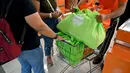 Seorang konsumen menggunakan tas belanja nonplastik untuk mengemas barang belanjaan di sebuah supermarket di Denpasar, 16 Juli 2019. Bali menerapkan pelarangan penggunaan plastik sekali pakai yang tertuang dalam Peraturan Gubernur (Pergub) Nomor 97 Tahun 2018. (SONNY TUMBELAKA/AFP)