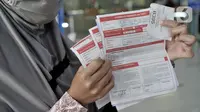 Warrga menunjukkan formulir pembatalan perjalanan kereta api di Stasiun Pasar Senen, Minggu (29/3/2020). PT KAI Daop 1 Jakarta membatalkan sejumlah perjalanan keberangkatan kereta jarak jauh hingga 1 Mei 2020 sebagai pencegahan penyebaran virus Corona. (merdeka.com/Iqbal Nugroho)