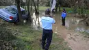 Para petugas sedang mengevakuasi mobil-mobil yang terkena serangan banjir bandang, Grabels, Prancis, Selasa (7/10/2014) (AFP PHOTO/Sylvain THOMAS)