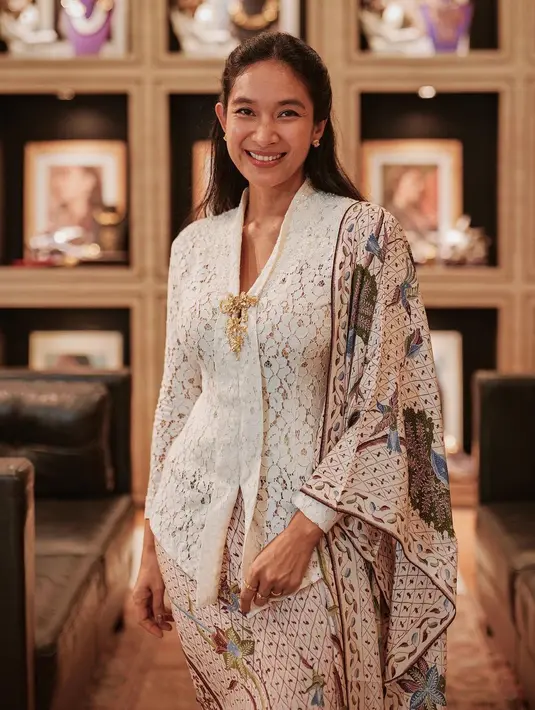 Happy Salma terlihat manis dalam balutan kebaya Kartini berwarna putih. Dipadukan dengan bros dan kain batik dengan dasar putih yang senada [@happysalma]