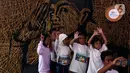 Anak-anak berfoto di depan karya instalasi bambu berbentuk wajah Jenderal Sudirman karya Nus Salomo yang dipamerkan pada Aksi BNI KEJAR atau Kenali Sejarah Raihlah Mimpimu di Terowongan Dukuh Atas, Jakarta, Minggu (24/11/2019). (Liputan6.com/Johan Tallo)