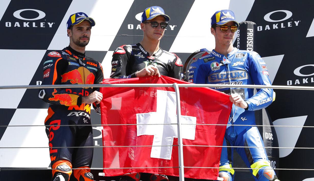 (ki-ka) posisi kedua pembalap KTM Miguel Oliveira, posisi pertama pembalap Yamaha Fabio Quartararo, dan posisi ketiga pembalap Suzuki Joan Mir memegang bendera Swiss untuk menghormati Jason Dupasquier pada MotoGP di Sirkuit Mugello, Scarperia, Italia, Minggu (30/5/2021). (AP Photo/Antonio Calanni)