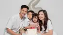 Anak keduanya genap berusia dua tahun, kebahagiaan terpancar jelas di wajah Tasya Kamila dan Randi Bachtiar. Tasya Kamila, Randi, dan si sulung Arassya selaras mengenakan busana putih, sementara Shafanina mengenakan dress simpel floral warna merah muda. Rambut gadis kecil yang akrab disapan Shanin itu dikepang dua sehingga membuatnya terlihat menggemaskan. (Liputan6.com/IG/@tasyakamila)