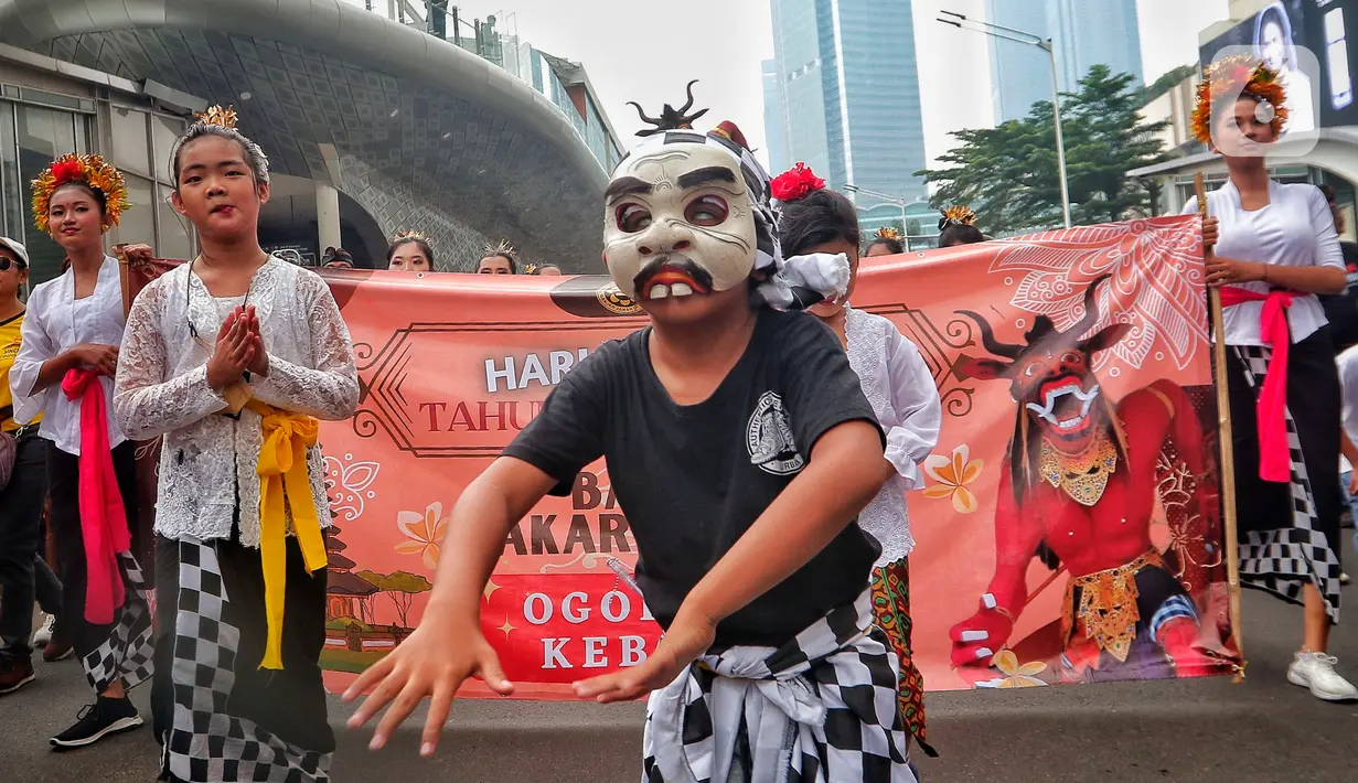 Penari saat mengarak ogoh-ogoh saat hari bebas berkendara di kawasan Bundaran HI, Jakarta, Minggu (12/3/2023). Ogoh-ogoh sendiri dalam kebudayaan Bali biasa menggambarkan kepribadian Bhuta Kala yang dalam ajaran Hindu Dharma merupakan kekuatan (Bhu) alam semesta dan waktu (Kala) yang tak terukur dan tak terbantahkan. (Liputan6.com/Angga Yuniar)