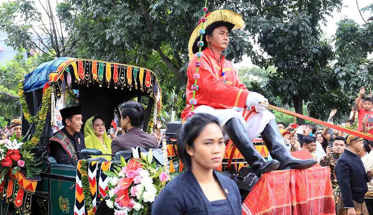 Sebelum duduk di pelaminan, pengantin yang tengah berbahagia itu menjalani kirab budaya. Diarak menggunakan kereta kuda dan melibatkan puluhan betor (becak motor). (Deki Prayoga/Bintang.com)